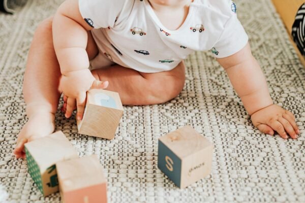 little baby playing with wooden blocks